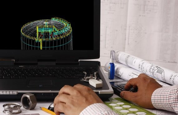 Engineer examining product blueprints on laptop