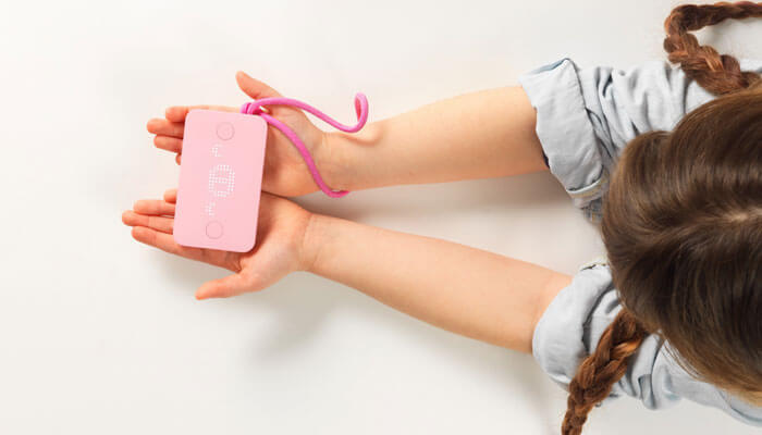 Child holding pink Pigzbe crypto storage wallet