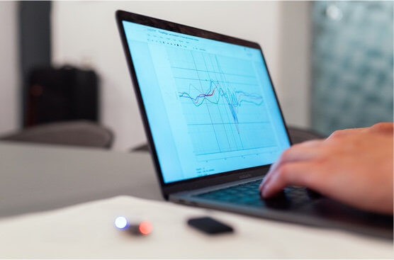 Engineer looking at product performance graphs on laptop