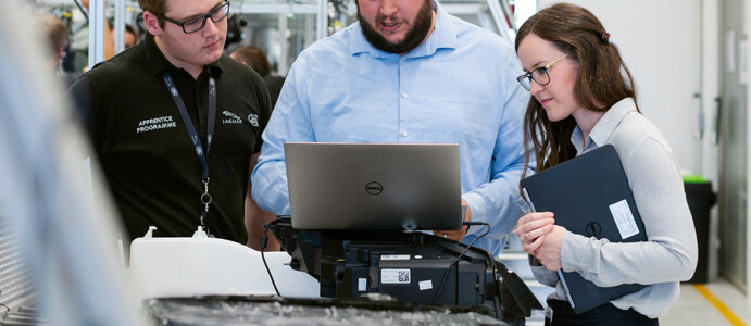 Group of engineers looking at a laptop